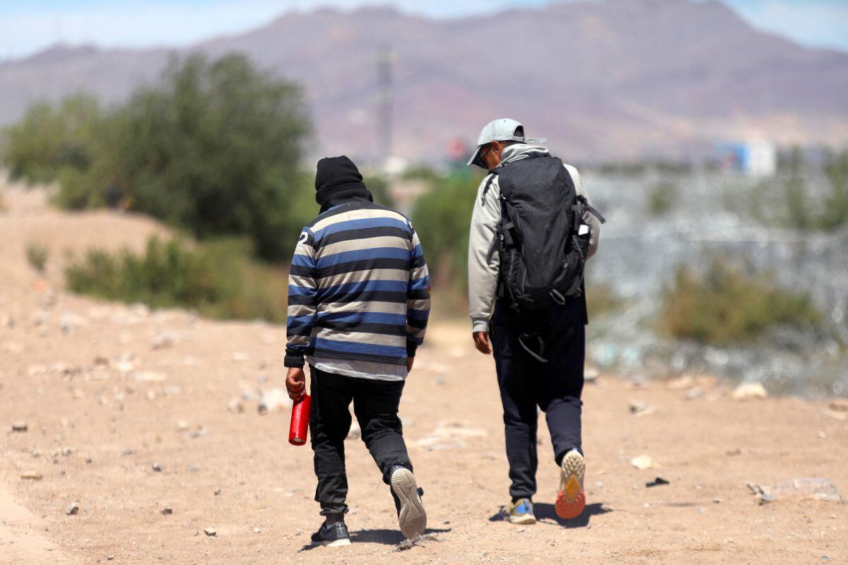 Dos migrantes caminan a lo largo de las orillas del Río Bravo en busca de una brecha para cruzar a Estados Unidos desde Ciudad Juárez, Chihuahua, México, el 18 de abril de 2024 (Foto: Herika Martínez / AFP)