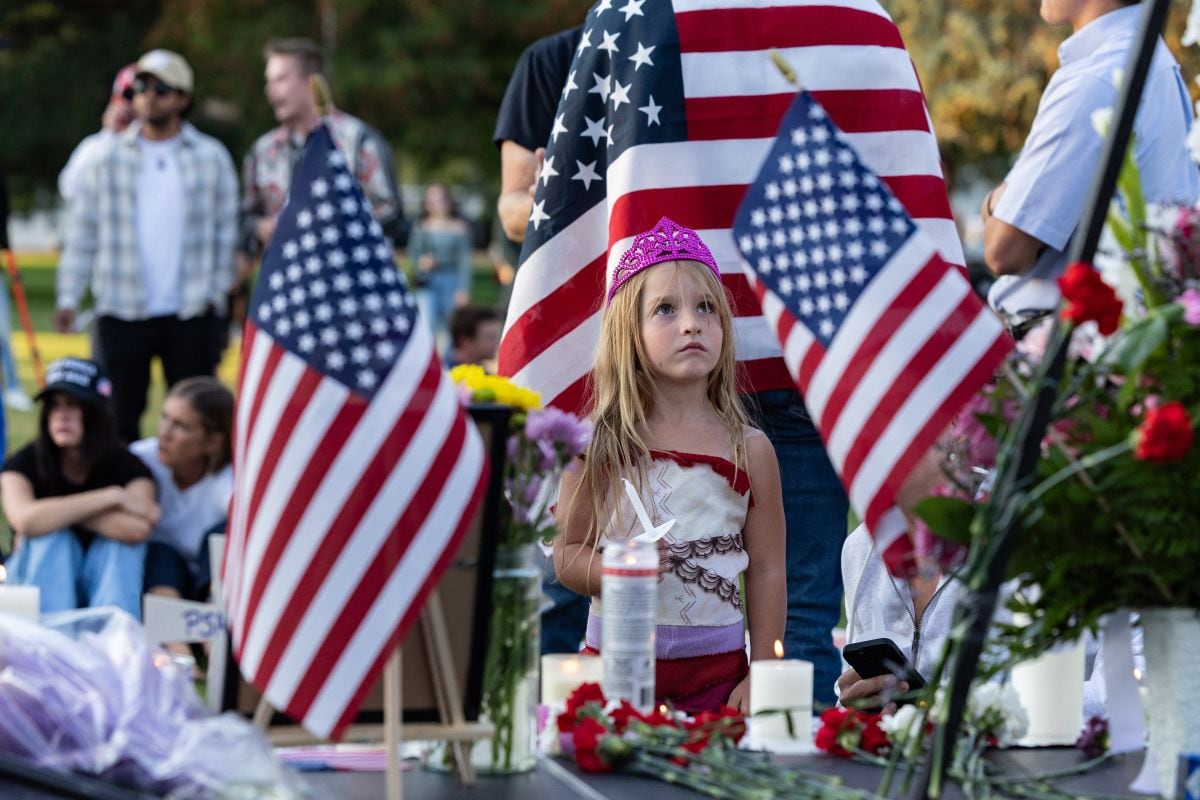 Una joven mira una fotografía de Charlie Kirk durante una vigilia con velas en memoria del activista de derecha en un memorial improvisado en Memorial Park, en Provo, Utah, el 12 de septiembre de 2025. Foto: Melissa MAJCHRZAK / AFP