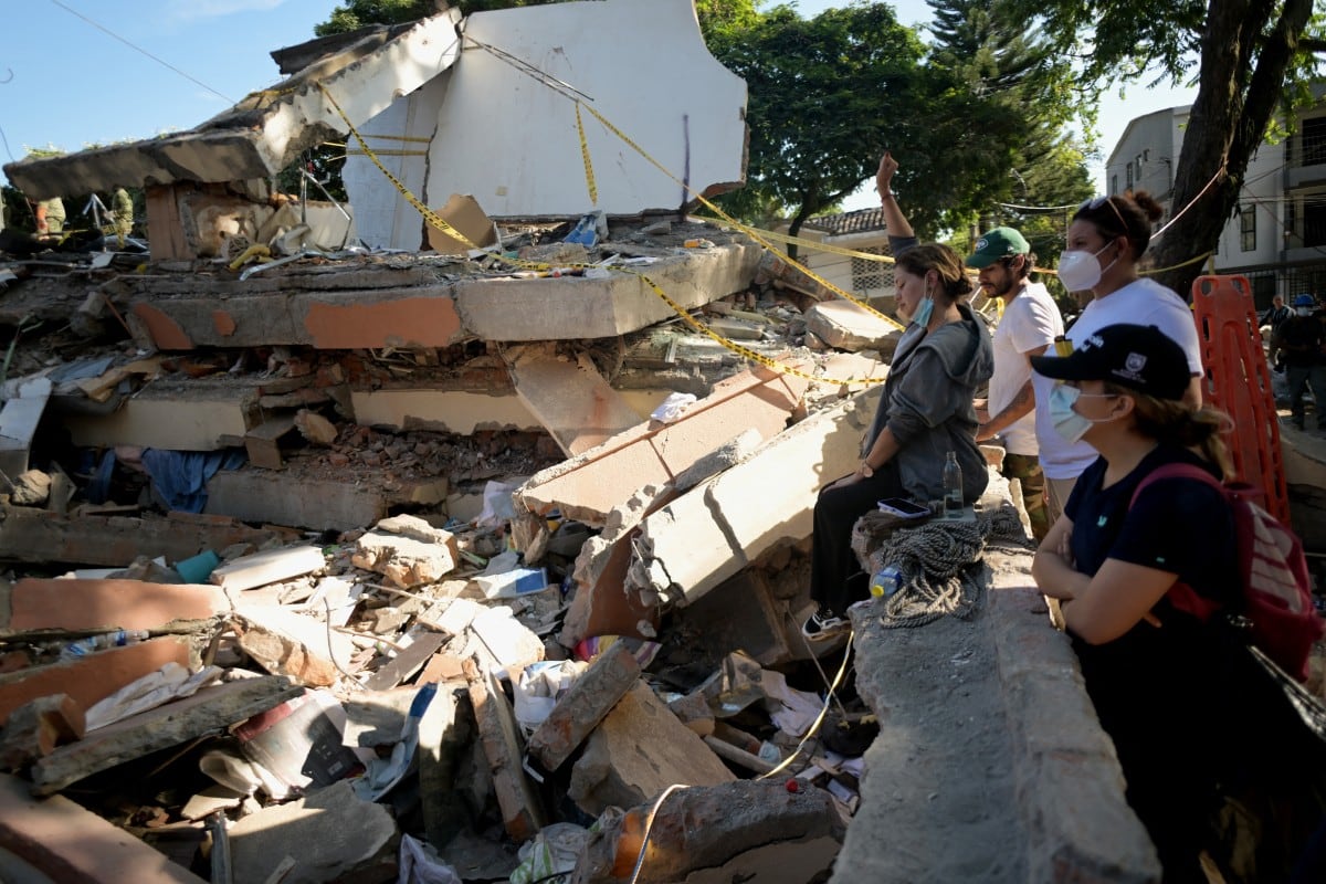 Una mujer hace un gesto entre los escombros de una casa derrumbada tras un terremoto en Cali, Colombia, el 11 de agosto de 2026. (JOAQUIN SARMIENTO / AFP)