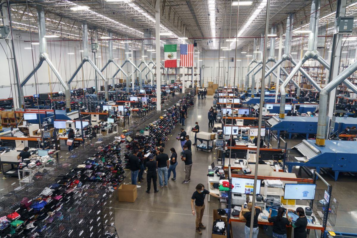 Workers design and print t-shirts at the TSC Miami factory in Ciudad Juarez, Chihuahua state, Mexico, on Wednesday, Dec. 1, 2021. The sprawling desert city of Juarez will house a long list of new factories that were ordered up by anxious CEOs across the world when the pandemic roiled their global supply routes. Photographer: Paul Ratje/Bloomberg