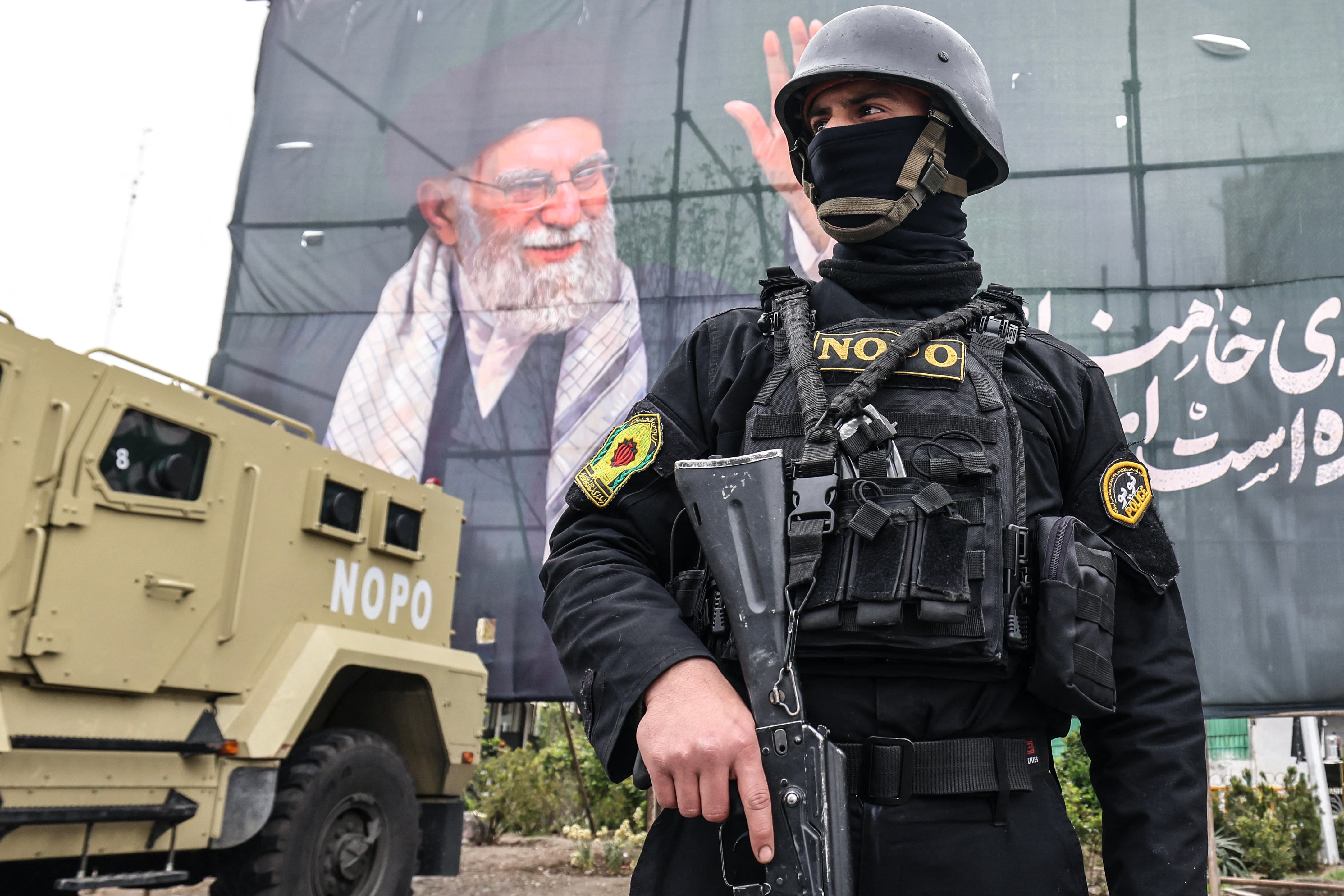 Un miembro de las fuerzas de seguridad de Irán monta guardia junto a una pancarta en honor al asesinado líder supremo, el ayatola Alí Jamenei, en Teherán, el 31 de marzo de 2026. (Foto de ATTA KENARE / AFP).