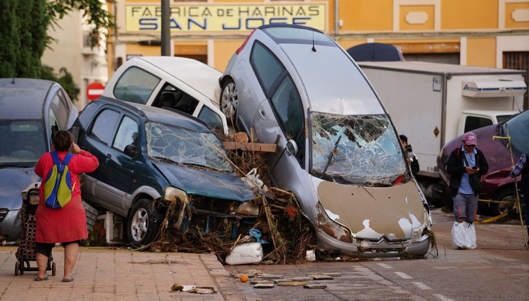 Una mujer toma fotografías de coches amontonados tras las mortales inundaciones en el barrio de De la Torre de Valencia, al sur de Valencia, este de España, el 30 de octubre de 2024 (Foto: Manaure Quintero / AFP)