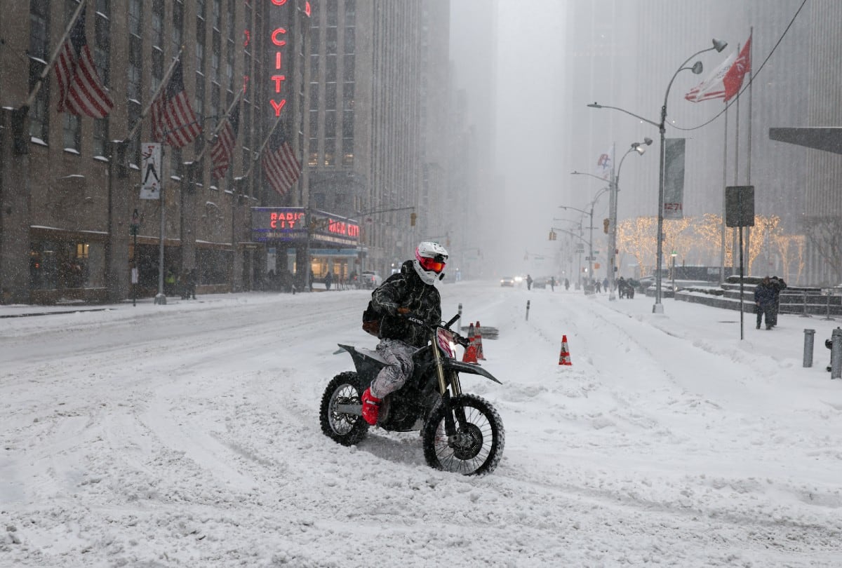 Una persona circula en moto por la nieve en Nueva York el 25 de enero de 2026, en plena tormenta invernal. | Crédito: CHARLY TRIBALLEAU / AFP