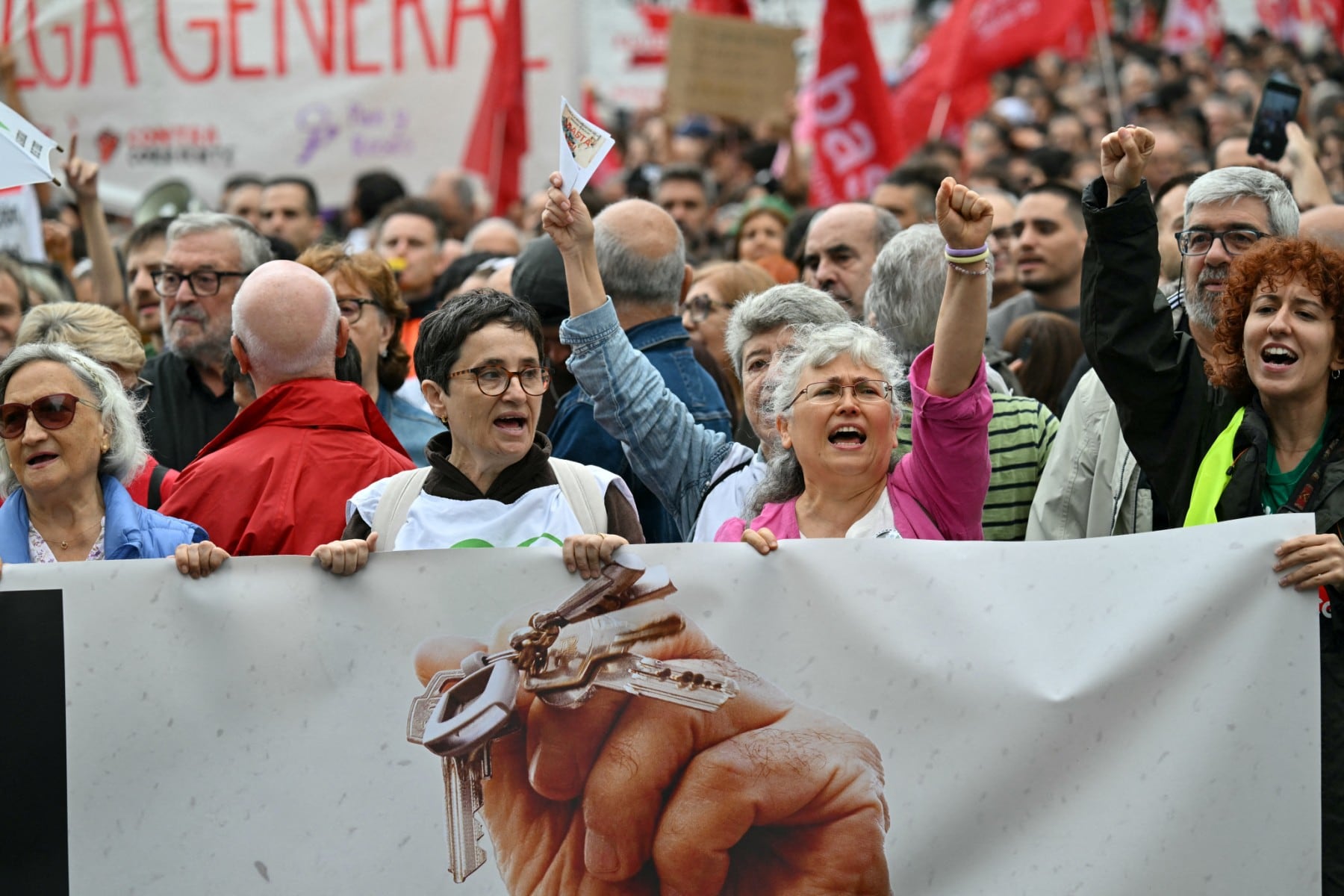 Unos manifestantes sostienen una pancarta con el lema «Huelga general» durante una protesta contra los desahucios y los altos precios de los alquileres en la plaza de España de Madrid, el 3 de octubre de 2026. (JAVIER SORIANO / AFP)