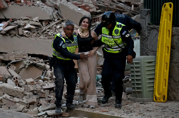Agentes de la policía municipal evacuan a una víctima herida de un edificio derrumbado tras un terremoto en Venezuela. Foto: ANDINA/AFP