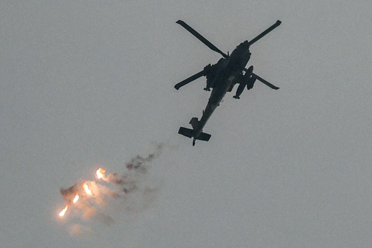 Un helicóptero de ataque de la fuerza aérea israelí lanza bengalas mientras vuela en un área a lo largo de la frontera con la Franja de Gaza, el 12 de diciembre de 2023. (Foto de JACK GUEZ / AFP)