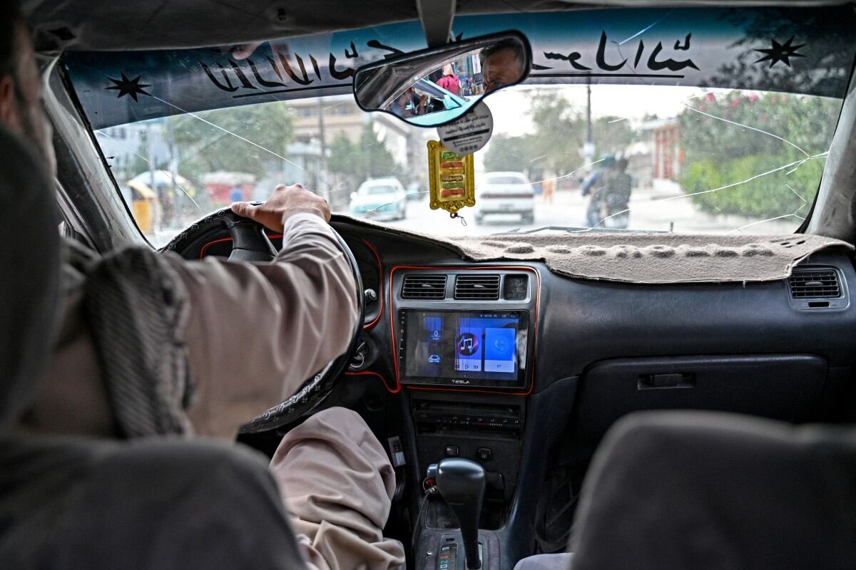 Esta fotografía, tomada el 14 de septiembre de 2026, muestra la pantalla de reproducción de música del equipo de sonido mientras un taxista afgano transporta pasajeros en Kabul. (Foto: AFP)