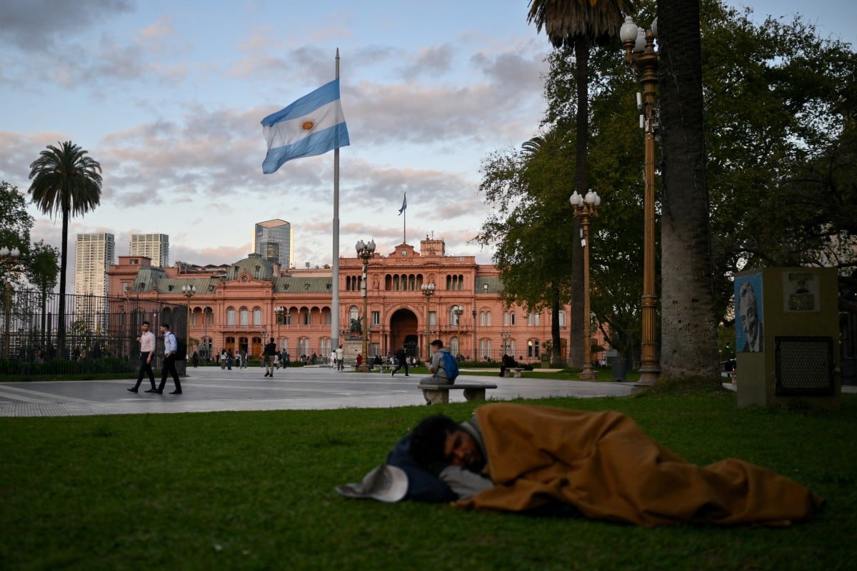 Un hombre sin hogar duerme en la Plaza de Mayo, frente a la Casa Rosada, palacio presidencial de Buenos Aires, el 25 de septiembre de 2024. La morosidad en los hogares argentinos se triplicó en doce meses y alcanzó en 2026 su nivel más alto en 20 años durante el gobierno de Javier Milei. (Foto de LUIS ROBAYO / AFP)