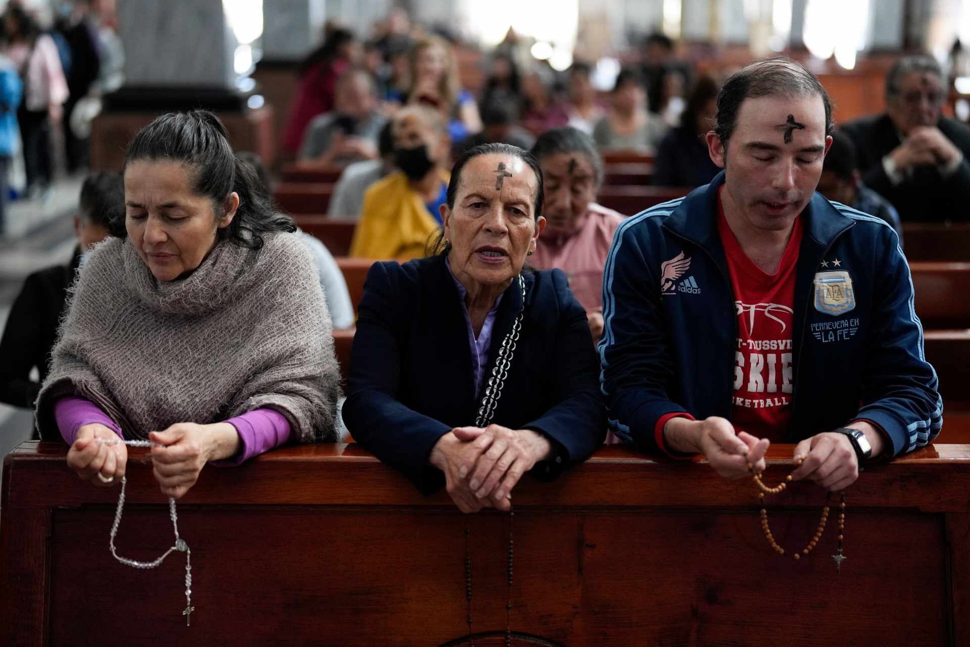 Católicos rezan el rosario al tiempo que un sacerdote marca la frente de los fieles con ceniza durante la misa del Miércoles de Ceniza en la Iglesia del Divino Niño en Bogotá, Colombia, el miércoles 14 de febrero de 2024. (Foto AP/Fernando Vergara, archivo)