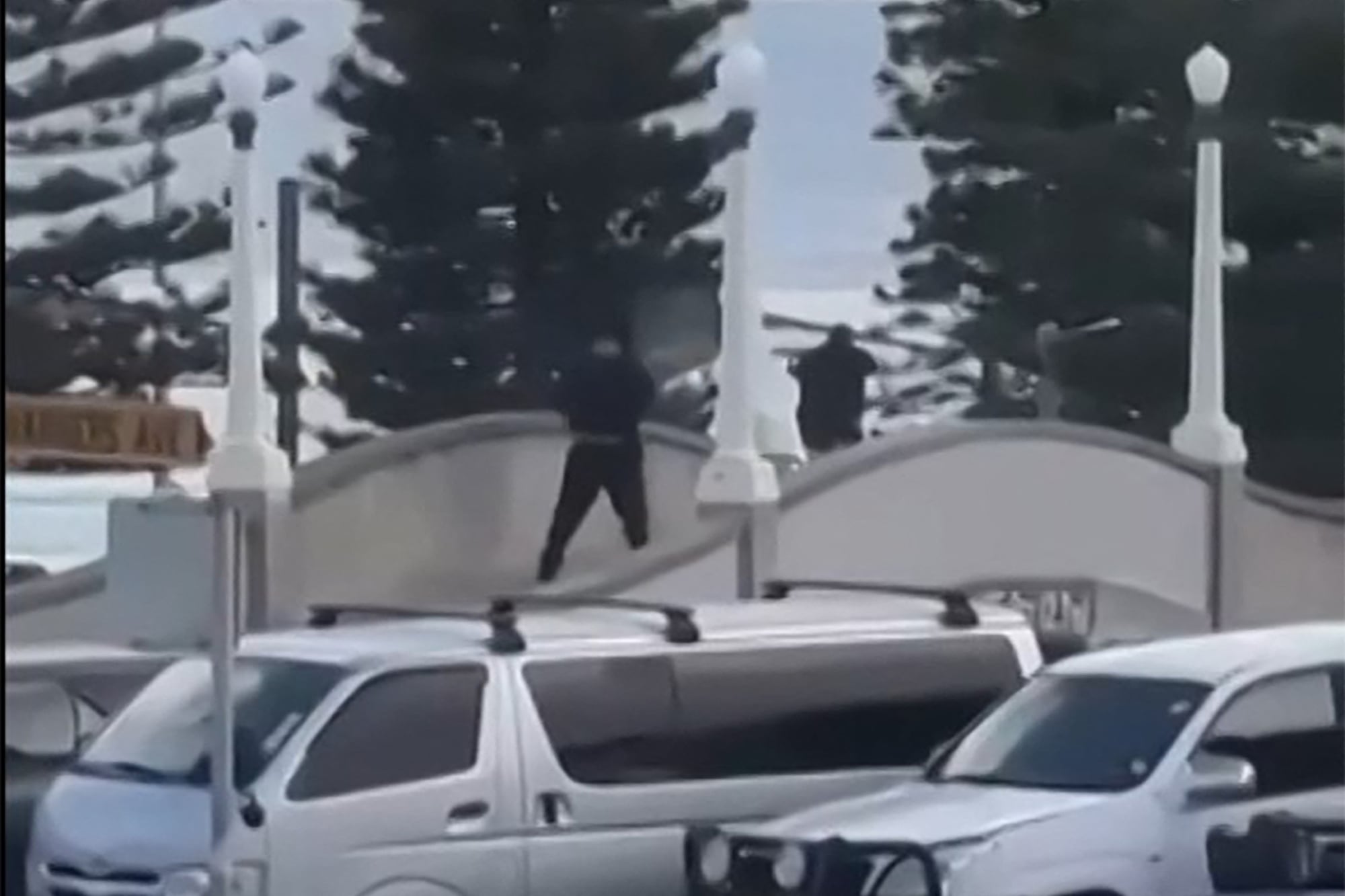 Esta captura de pantalla muestra a dos hombres armados vestidos de negro disparando en Bondi Beach, Sídney, Austrakia, el 14 de diciembre de 2025. (AFP).