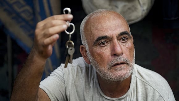 Hassan Nofal, de 53 años, quien fue desplazado debido al bombardeo israelí de la Franja de Gaza, muestra las llaves de la casa a la que tuvo que abandonar con su familia para ir a un campamento de carpas en Jan Yunis en el sur de la Franja de Gaza. (Foto AP /Abdel Kareem Hana)