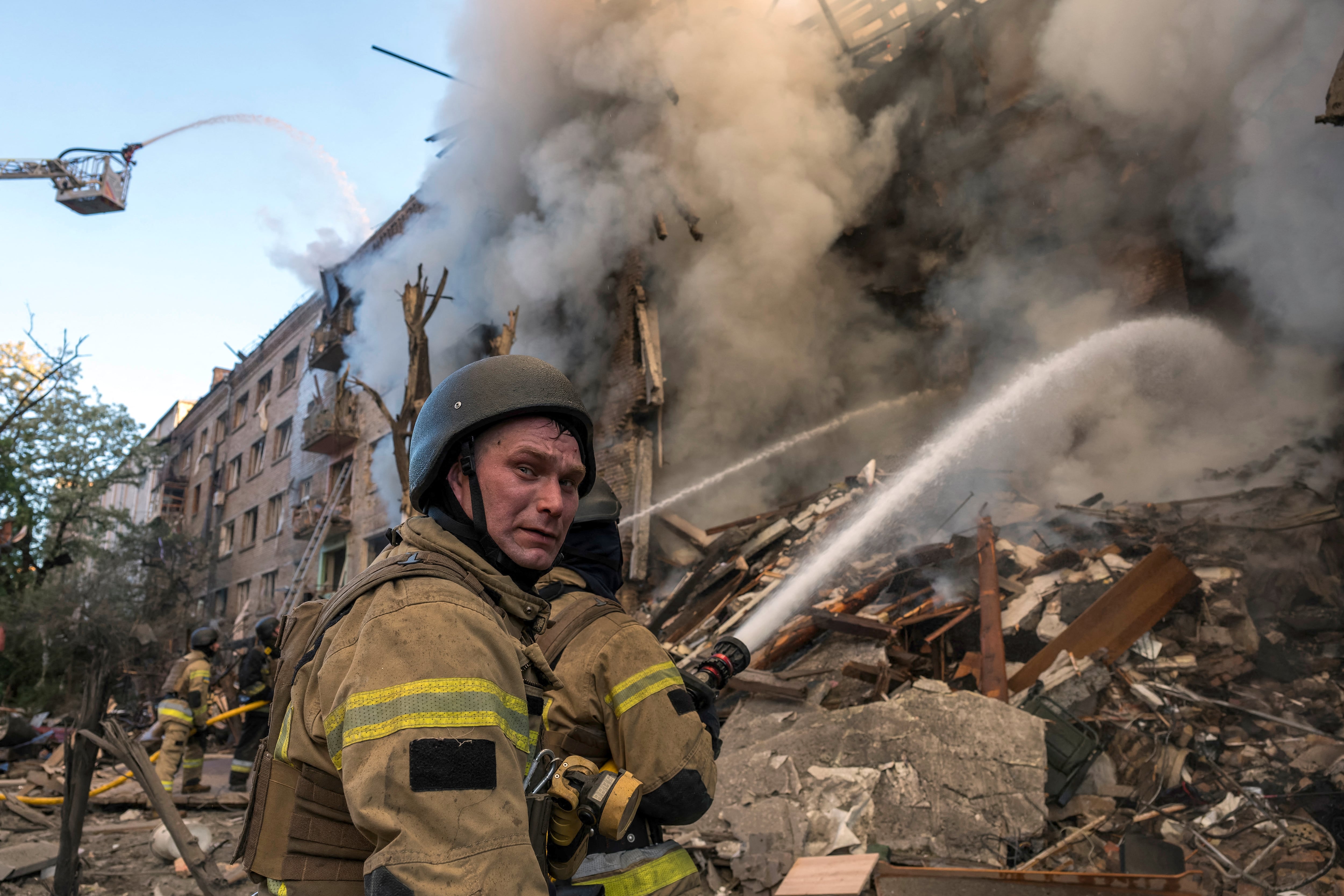 Los bomberos trabajan para extinguir un incendio en un edificio gravemente dañado tras los ataques de Rusia contra la capital de Ucrania, Kiev. (Foto de Vladyslav MUSIENKO / AFP).
