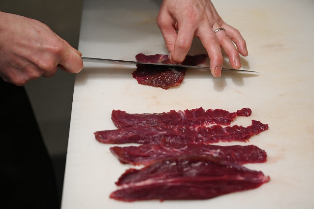 Esta foto, tomada el 9 de diciembre de 2025, muestra al chef Kiyoshi Fujimoto cortando carne de oso en su restaurante de Sapporo, en la prefectura de Hokkaido, al norte de Japón. (Foto de GREG BAKER / AFP)