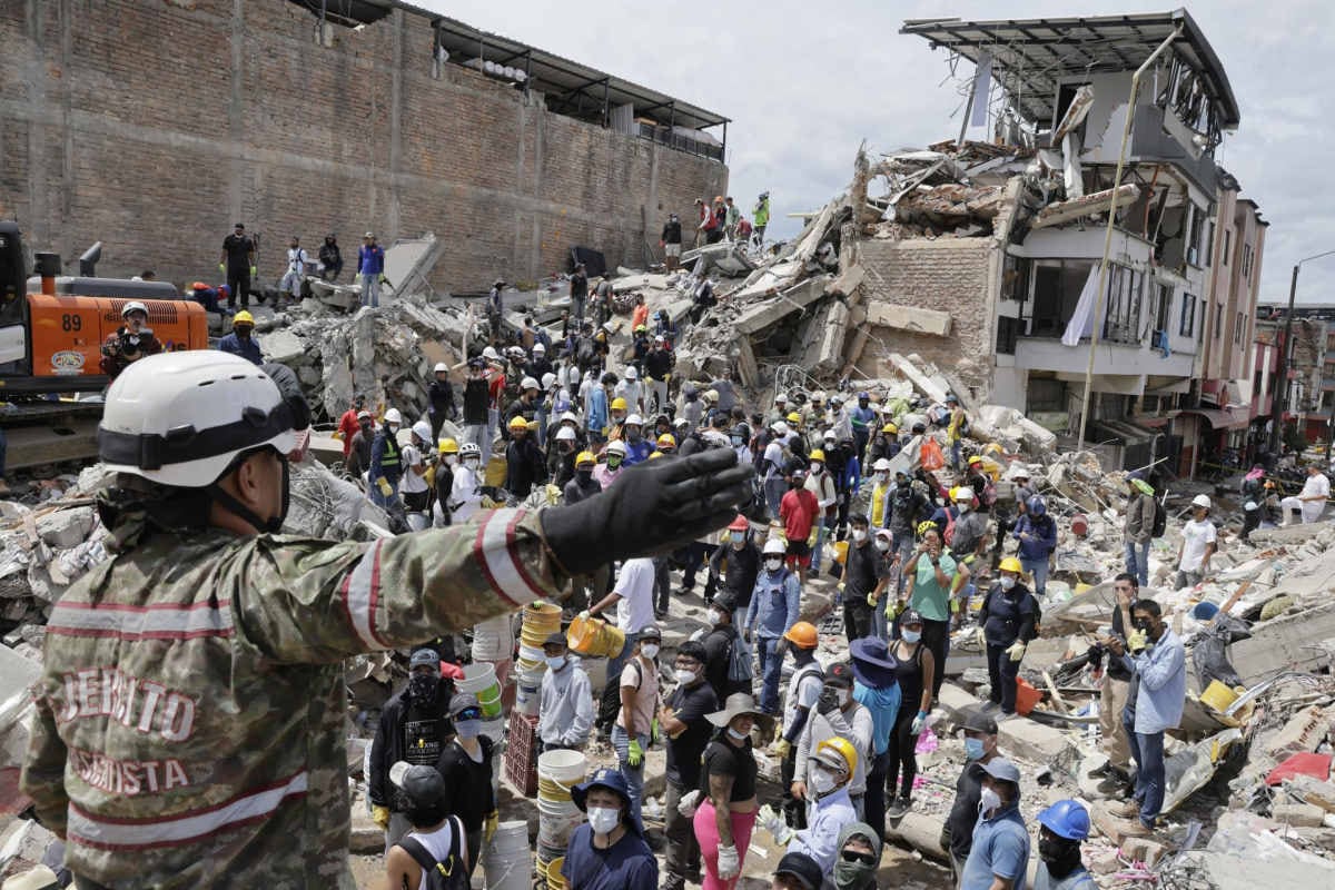 Una rescatista del Ejercito de Colombia da indicaciones a un grupo de voluntarios que realiza labores de búsqueda en edificaciones destruidas por el terremoto de magnitud 7.4 del pasado lunes, este miércoles en Pereira. Foto: EFE/ Carlos Ortega