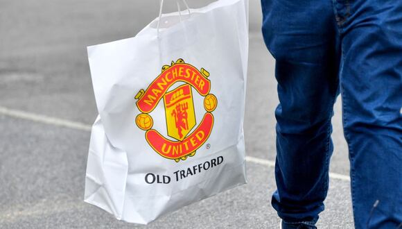 A customer leaves after shopping at the Megastore at Old Trafford football ground, home of Manchester United Football Club, in Manchester, UK, on Friday, Aug. 19, 2022. Manchester United FCs owners are considering opening up the iconic English football club to a new investor -- with private equity firms likely to be crowding the field alongside high-net worth individuals. Photographer: Anthony Devlin/Bloomberg