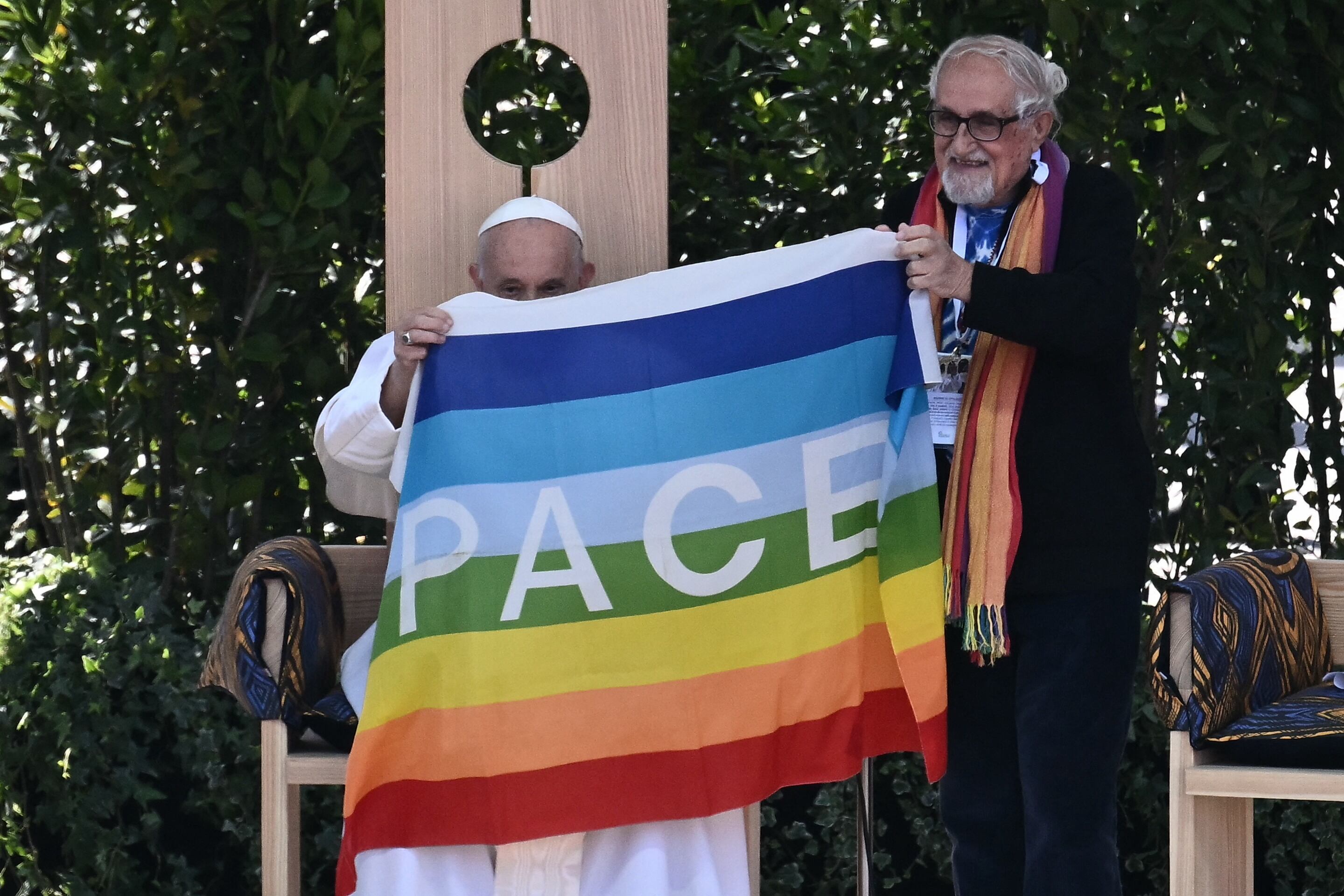 El padre Alex Zanotelli presenta una bandera donde dice paz al papa Francisco durante un encuentro en Verona, el 18 de mayo de 2024. (Foto de Marco BERTORELLO / AFP).
