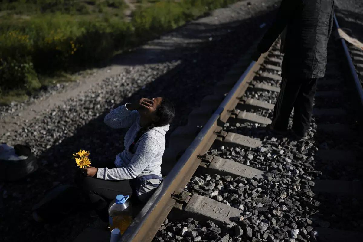Una mujer migrante sentada al lado de las vías del tren con la esperanza de subirse a un tren de mercancías con ruta al norte en Huehuetoca, México (Foto: Associated Press)