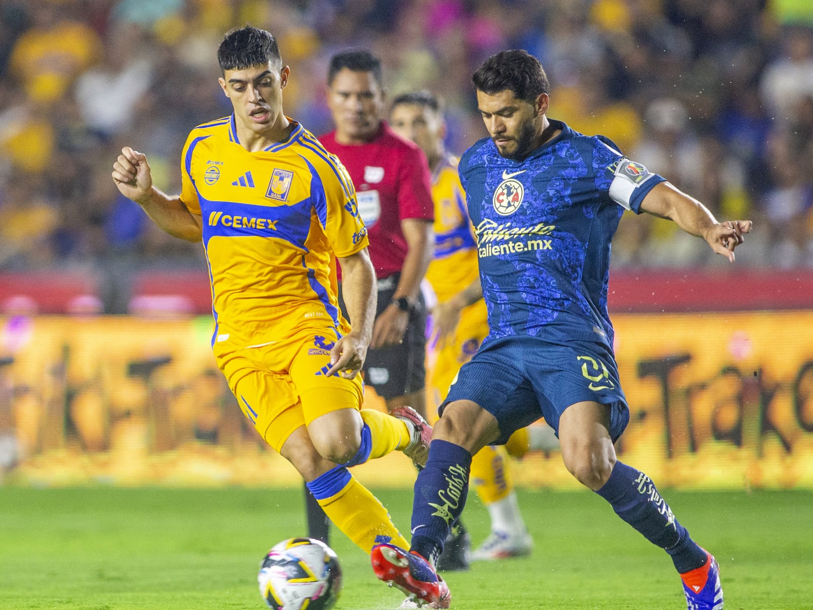 El centrocampista argentino de Tigres Juan Brunett y el delantero del América Henry Martin luchan por el balón durante el partido de la Liga MX Apertura de fútbol entre Tigres y América. (Foto: AFP)