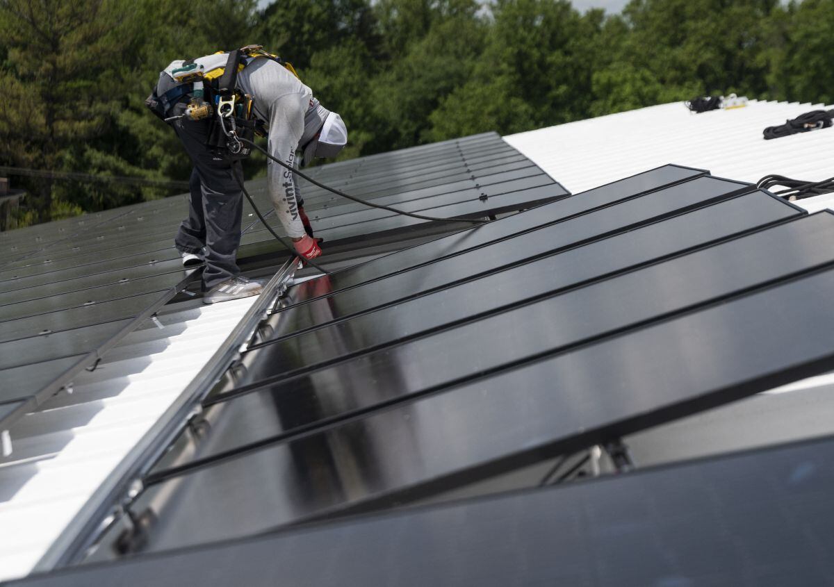 Un empleado de Ipsun Solar instala paneles solares en el techo de la Iglesia Luterana de la Paz en Alexandria, Virginia, el 17 de mayo de 2021 (Foto: Andrew Caballero-Reynolds / AFP)