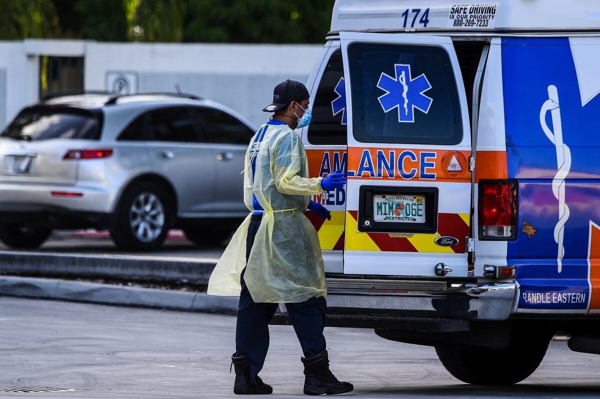 Un paramédico se prepara para trasladar a un paciente en camilla desde una ambulancia en el Hospital Coral Gables, cerca de Miami (Foto : de CHANDAN KHANNA / AFP).