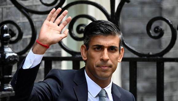 El recién nombrado primer ministro del Reino Unido, Rishi Sunak, saluda mientras posa frente a la puerta del número 10 de Downing Street en el centro de Londres, el 25 de octubre de 2022. (JUSTIN TALLIS / AFP).