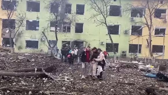 En esta captura de video del 9 de marzo de 2022,  personas se apoyan para salir de un edificio dañado de un hospital infantil luego de un ataque aéreo ruso en la ciudad de Mariupol. (Foto:  National Police of Ukraine / AFP)