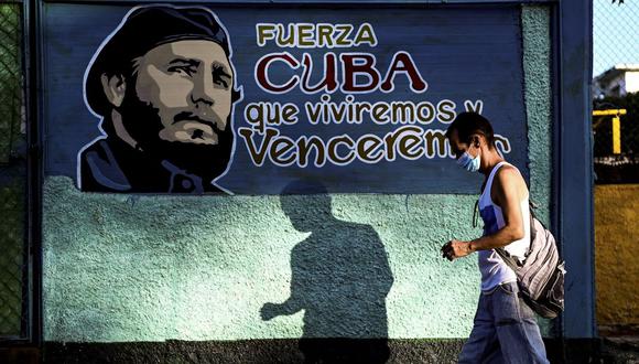 Un hombre camina junto a un mural que representa al fallecido líder cubano Fidel Castro en La Habana, Cuba, el 13 de agosto de 2021. (Foto de YAMIL LAGE / AFP).