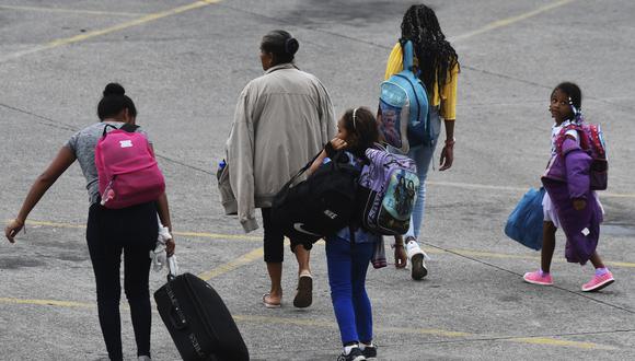 Una familia llega a la estación de autobuses Gran Central Metropolitana, desde donde la caravana migrante partirá hacia EE.UU. en San Pedro Sula, Honduras, el 20 de octubre de 2022. (Foto de Orlando SIERRA / AFP)
