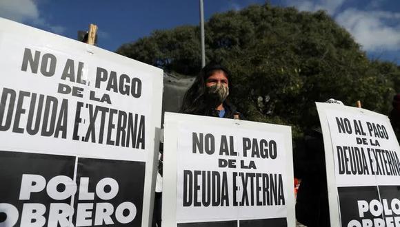 Un manifestante sostiene un cartel que dice "No al pago de la deuda externa" durante una protesta para exigir mejores salarios, vacunas y recursos para los comedores populares en Buenos Aires, Argentina. (Foto: REUTERS/Agustin Marcarian)