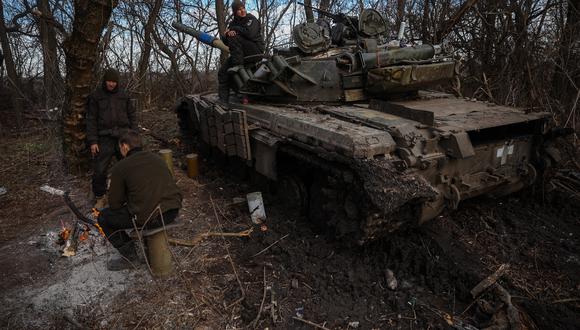 Los militares ucranianos se calientan junto a su tanque en una posición cerca de Bakhmut, región de Donetsk, el 30 de noviembre de 2022. (Foto: ANATOLII STEPANOV / AFP)