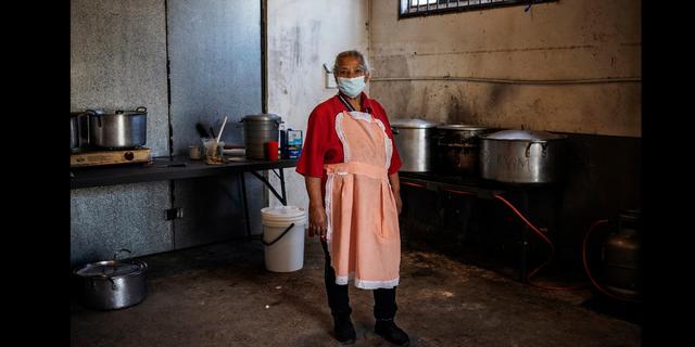 FOTO 2 | Sudáfrica. Una maestra de escuela posa en una cocina improvisada en el suburbio de Malvern en Johannesburgo. Rize Jacobs, de 63 años, es voluntaria como cocinera para un comité cívico que prepara y distribuye paquetes de alimentos para personas necesitadas durante la pandemia por Covid-19. "Si ves a un niño sentado en un rincón, sin comer nada, entonces es por eso que lo hago", explicó. Foto Afp / Michele Spatari