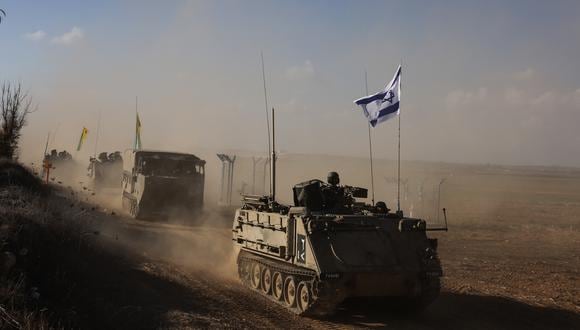 Un convoy de vehículos militares israelíes circula por una carretera en un lugar no revelado en la frontera con la Franja de Gaza el 15 de octubre de 2023. (Foto de Menahem KAHANA / AFP).