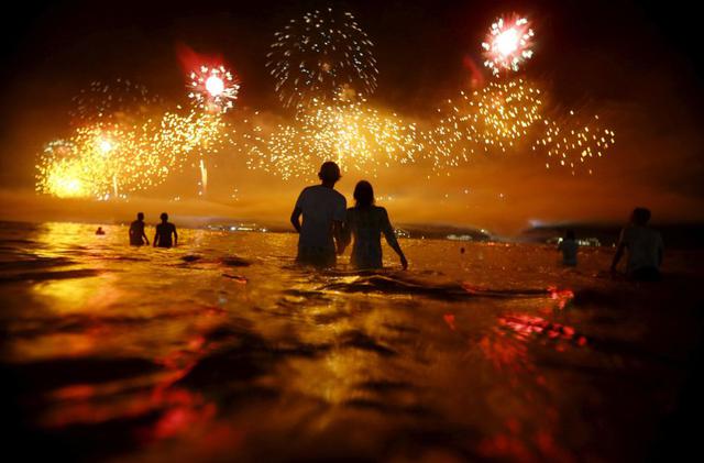 Un grupo de personas observan los fuegos artificiales en Río de Janeiro durante la celebración del Año Nuevo. (Foto Reuters)