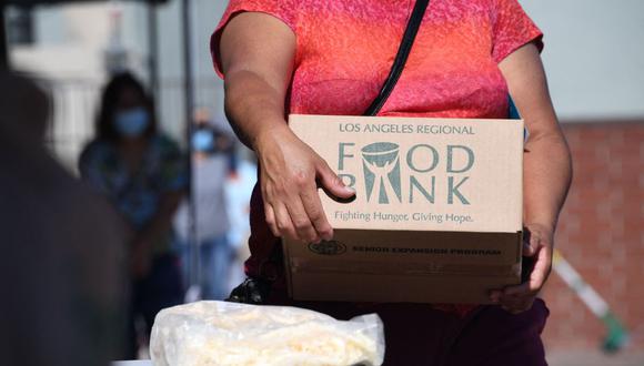 Una persona recoge una caja de comida en un banco de distribución de alimentos sin cita previa en Los Ángeles. Fotógrafo: Robyn Beck/AFP/Getty Images