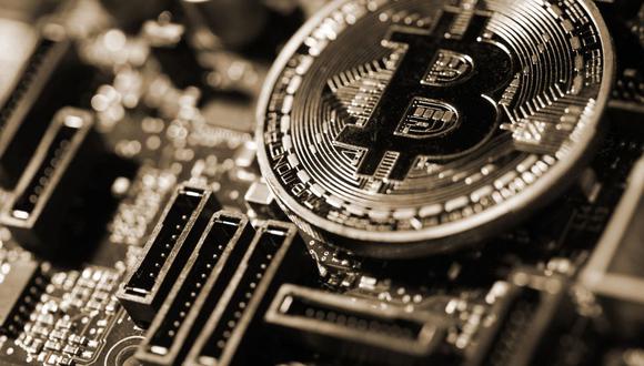 Una moneda que representa la criptomoneda Bitcoin se encuentra en una placa de circuito de computadora en esta fotografía arreglada en Londres, Reino Unido, el martes 6 de febrero de 2018. Fotógrafo: Chris Ratcliffe/Bloomberg