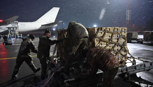 En esta foto de archivo tomada el 5 de febrero de 2022, militares de las Fuerzas Militares de Ucrania descargan un avión que transportaba ayuda militar estadounidense en el aeropuerto Boryspil de Kyiv el 5 de febrero de 2022. (Foto de GENYA SAVILOV / AFP)