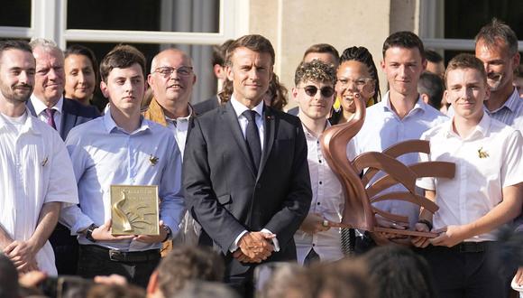 El presidente francés posa con los laureados de 'Worldskills' al inaugurar una exposición sobre el tema "Hecho en Francia" en el Palacio del Elíseo, en París, el 30 de junio de 2023. (Foto de Michel Euler / POOL / AFP)