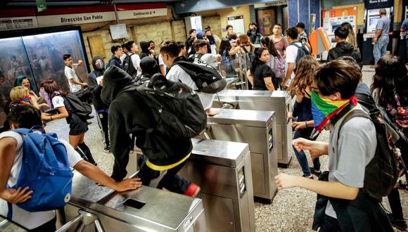 Escolares ingresan al metro de Santiago sin pagar sus pasajes.  AFP