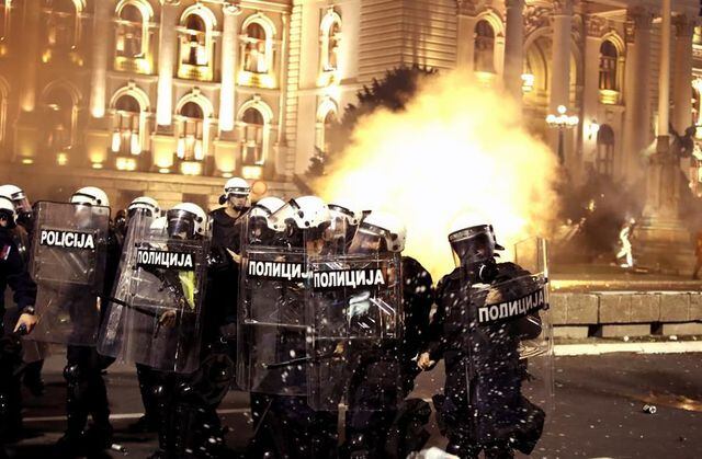 Manifestantes chocan con la policía frente al edificio del Parlamento en Belgrado durante una protesta contra el toque de queda por coronavirus (EFE / EPA / KOCA SULEJMANOVIC).