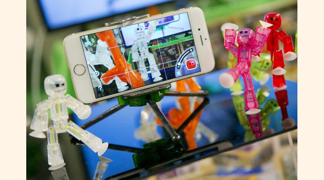 Muñecos de StikBot son exhibidos junto a un iPhone en el TTPM Holiday Showcase en Nueva York. Los muñecos son fáciles de maniobrar y pueden ser fotografiados varias veces para luego juntar las imágenes en una película utilizando la aplicación StikBot Stud