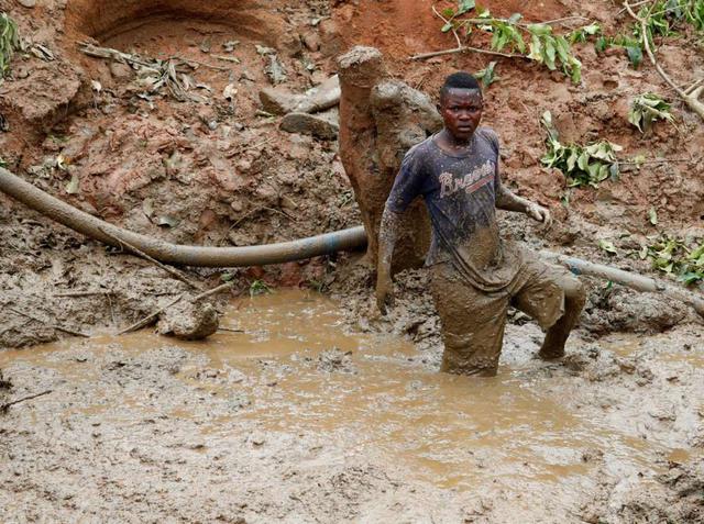 FOTO 9 | Otro joven minero sumergido en el barro hasta las rodillas.