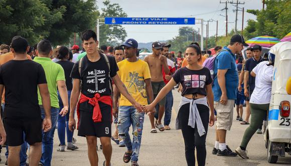 Migrantes, en su mayoría venezolanos, caminan por una calle mientras esperan su documento de libre tránsito, que se tramita en la localidad de San Pedro Tapanatepec, estado de Oaxaca, México, el 19 de octubre de 2022. (Foto de FRANCISCO RAMOS / AFP)