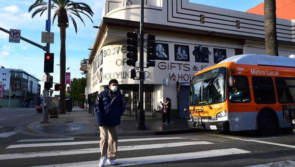 Un hombre usa una máscara facial mientras cruza una calle en Hollywood, California, un día después de que el condado de Los Ángeles anunciara un cierre casi total, instando a todos los residentes a quedarse en casa, excepto por las necesidades esenciales debido a la pandemia de coronavirus (Foto: AFP)