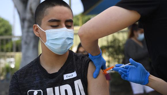 Héctor Garnica, de 13 años, recibe una primera dosis de la vacuna Pfizer contra el coronavirus Covid-19 en Los Ángeles, Estados Unidos. (Foto de Patrick T.FALLON / AFP).