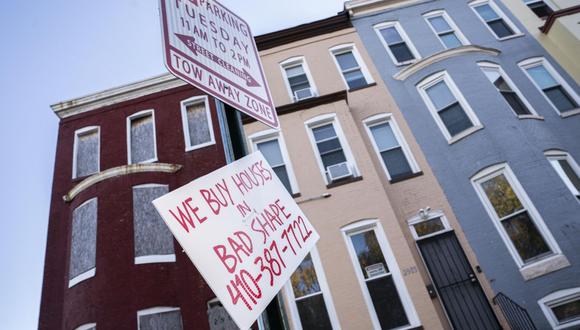 Un letrero para comprar casas frente a casas adosadas abandonadas y habitadas a lo largo de Walbrook Avenue en West Baltimore, Maryland, EE. 9 de enero de 2022. (Fotógrafo: Nathan Howard/Bloomberg)