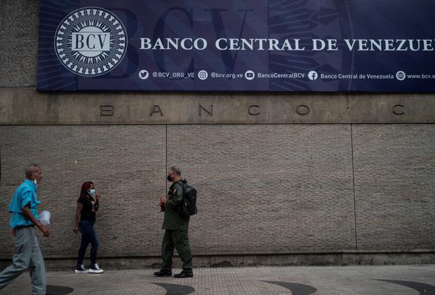 La gente camina frente a la fachada principal del Banco Central de Venezuela en Caracas el 25 de agosto de 2022. (Foto de Yuri CORTEZ / AFP)