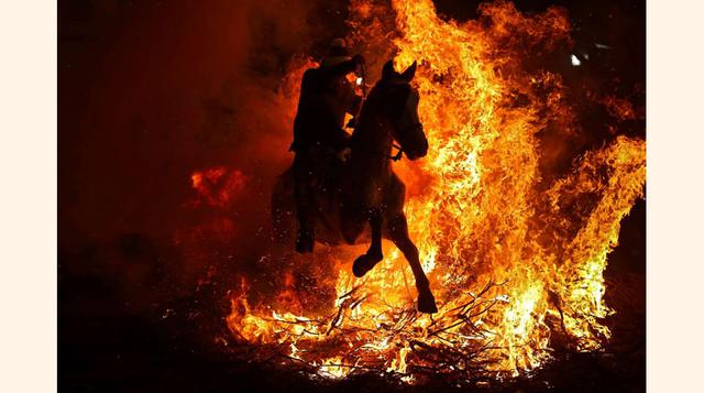 San Bartolomé de Pinares, España; Un hombre a caballo atraviesa una hoguera como parte de una fiesta en honor a San Antón Abad, patrón de los animales domésticos, el 16 de junio.(foto: Francisco Seco/AP Images).