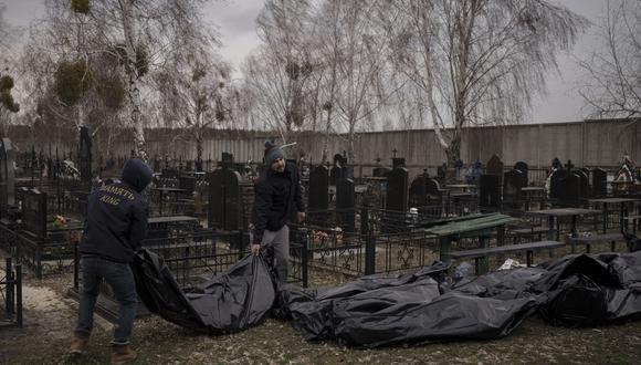 Ucranianos colocando los cadáveres en un cementerio improvisado tras el ataque ruso en Bucha. (AP/Felipe Dana)