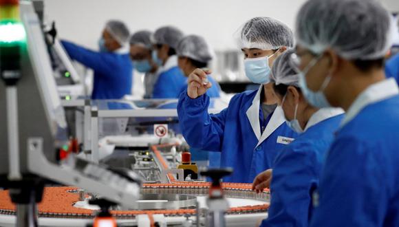 Personas trabajan en el desarrollo de una vacuna experimental contra el coronavirus en las instalaciones de Sinovac Biotech, en Beijing, China, el 24 de setiembre de 2020. (REUTERS/Thomas Peter).